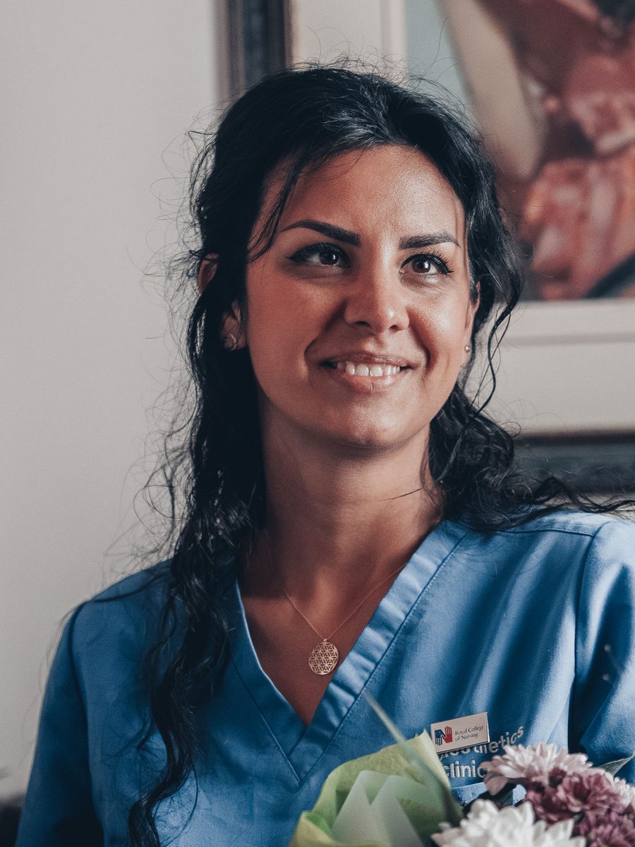 Ioana “Jo” Marcu, the clinic's aesthetic nurse prescriber, in blue scrubs at Pure Aesthetics Clinic
